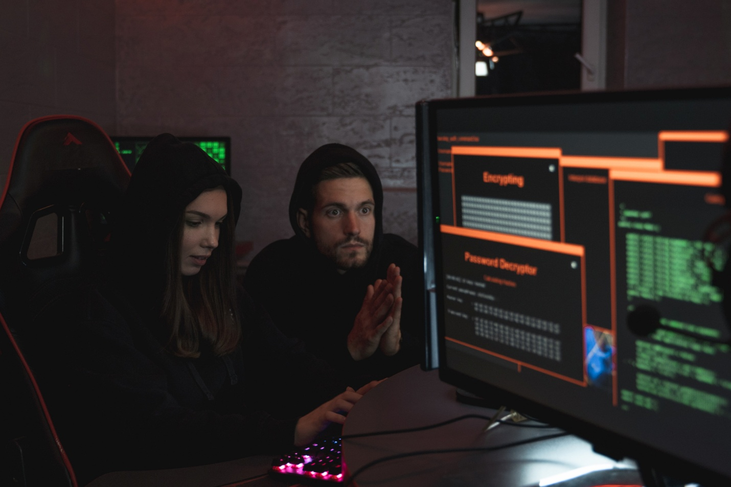 A man and a woman hacking a computer system