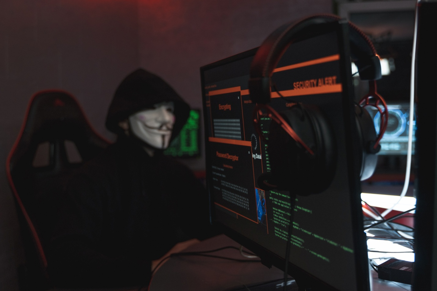 A person in a black hoodie hacking a computer system